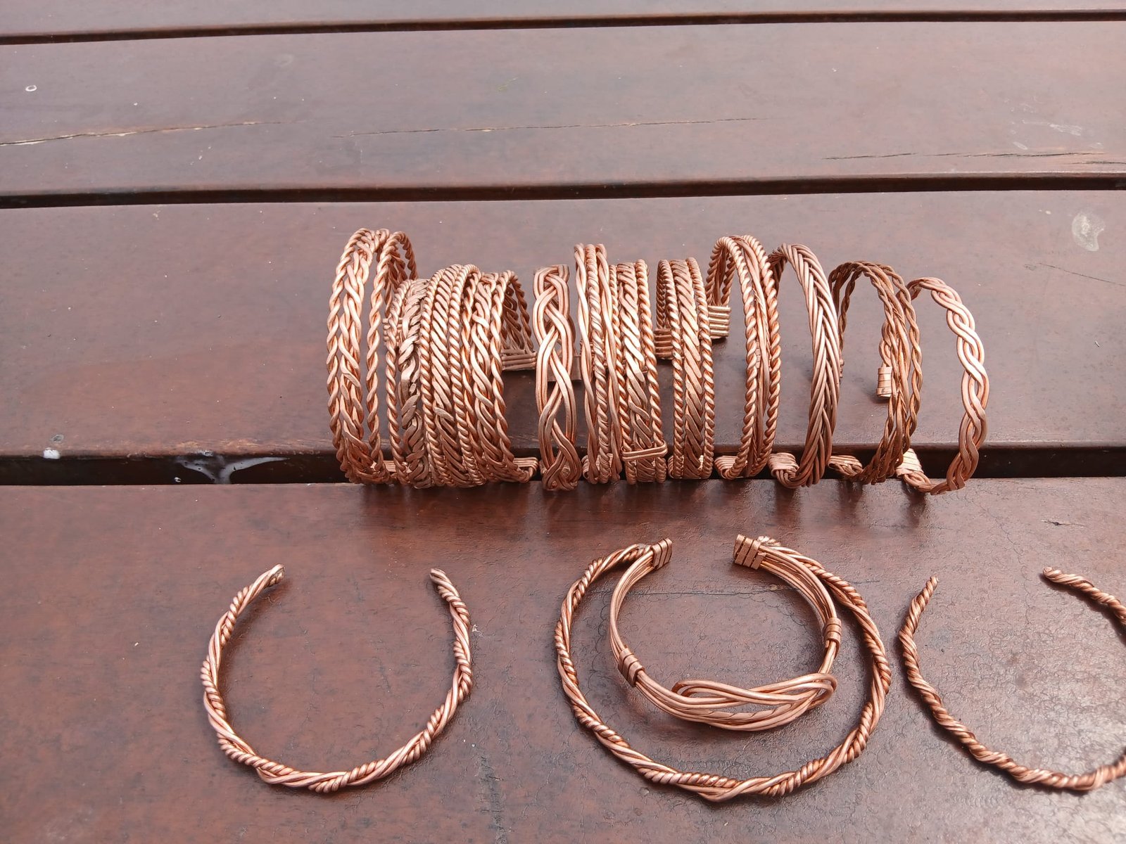 A pile of handmade copper bangles